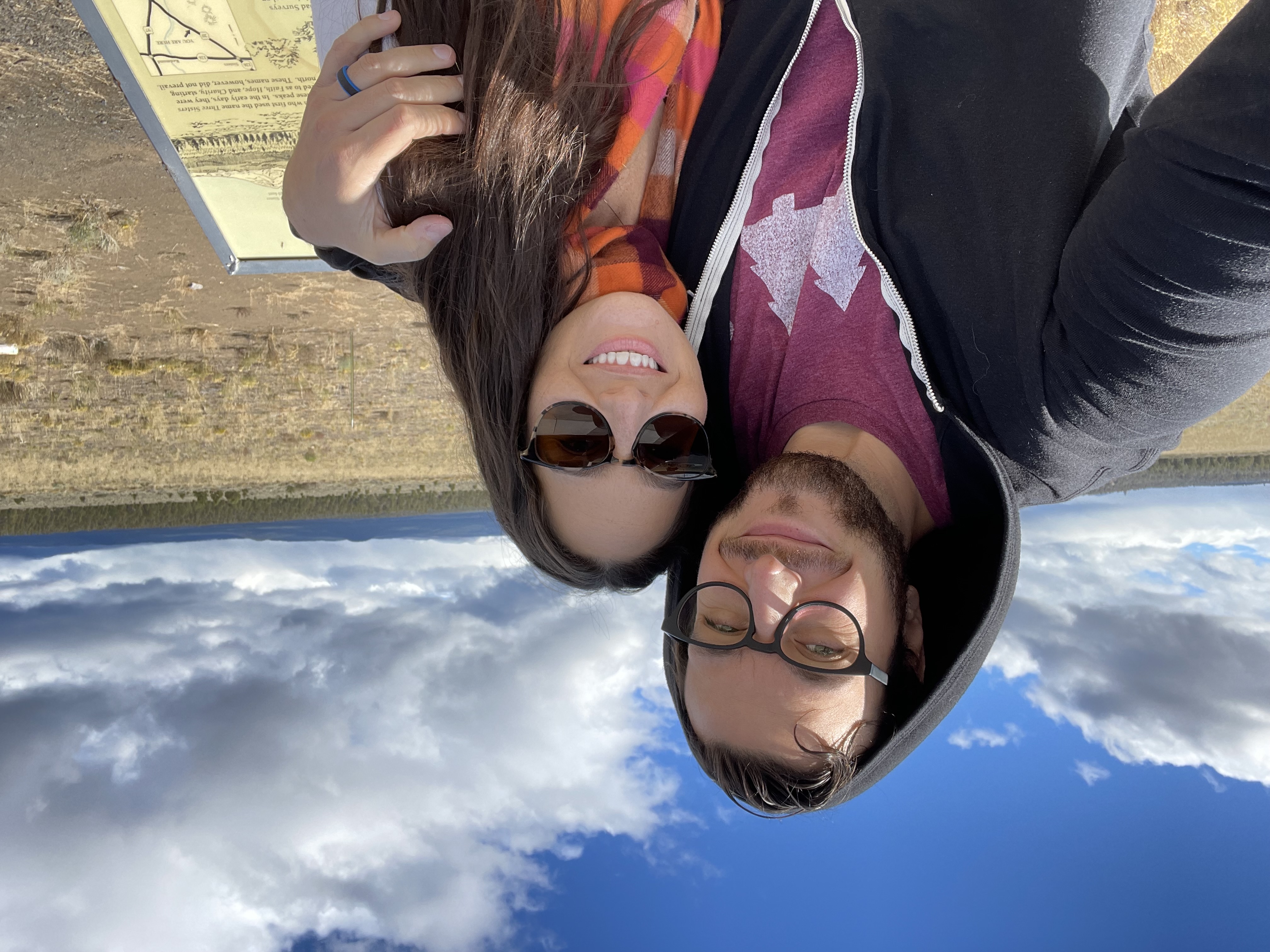 Samantha and a friend taking a selfie with rolling hills behind them